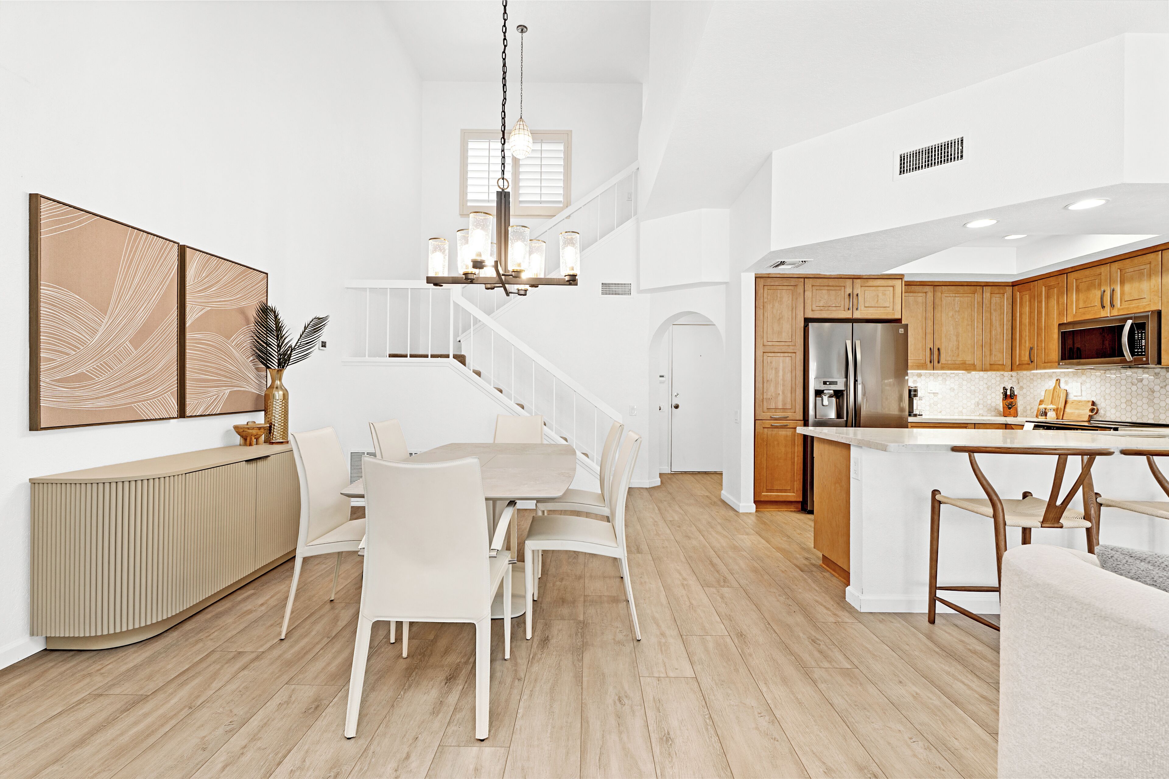 A modern kitchen with wooden cabinets, a stainless steel refrigerator, and a microwave.