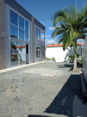 A modern building with large windows and a gravel courtyard.