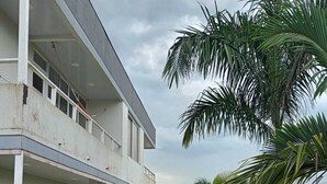 A two-story building with a flat roof, a covered patio area, and a well-maintained lawn.