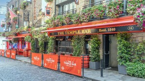 The Temple Bar -pubin ulkotilojen rivi, jossa on istumapaikkoja. Pub on perustettu vuonna 1840, ja taustalla näkyy mukulakivikatu.
