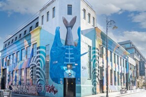 A building with a mural of a mermaid tail, a sign for 'MORGAN,' and a bike parked outside. - Guestready - Fownes Street (Dublin)