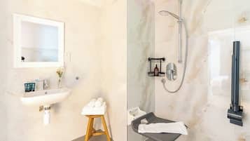 Ein Badezimmer mit Waschbecken, Spiegel, Handtuchhalter und Dusche.