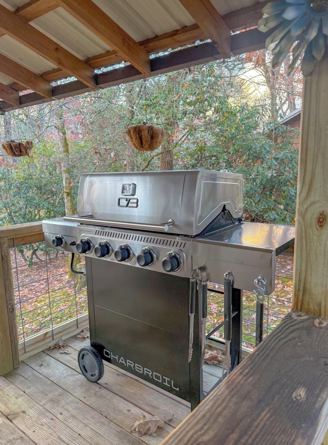 Un barbecue à gaz Charbroil doté de quatre brûleurs, d’un panneau de commande et d’une table d’appoint.