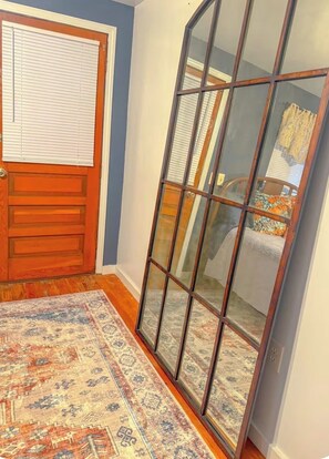 A room with a wooden door, a large glass sliding door, and a patterned rug on the floor. - New Cabin in lake toxaway near gorges state park (Lake Toxaway)