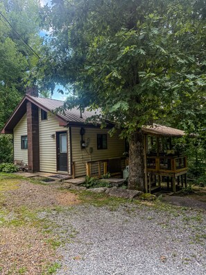 A single-story house with a porch, a chimney, and a tree in front. - New Cabin in lake toxaway near gorges state park (Lake Toxaway)