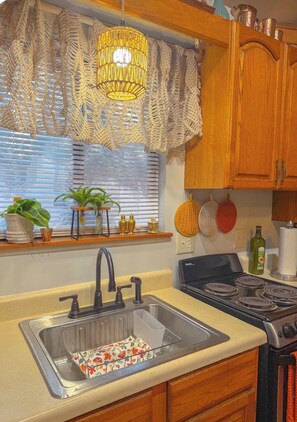 A kitchen with a sink, stove, and wooden cabinets. - New Cabin in lake toxaway near gorges state park (Lake Toxaway)