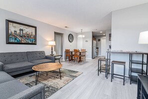 En moderne stue med sofa, sofabord og spiseplads.