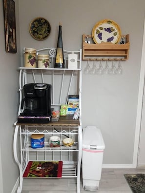 A kitchenette with a coffee maker, jars, a wine bottle, and a wine rack. - The "Merlot" - Updated Condo - DISCOUNT 4+ nights! (Branson)