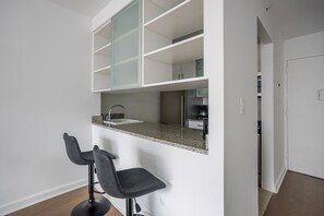 Eine moderne Küche mit integriertem Spülbecken, einer Arbeitsplatte und einem Stuhl.
