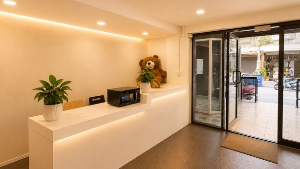 Un comptoir d’accueil agrémenté d’une plante en pot, d’un ours en peluche et d’un four à micro-ondes.
