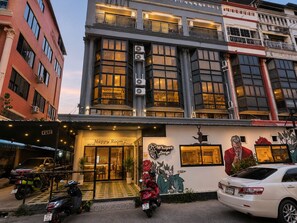 A hotel entrance with a sign for 'Happy Room 2 Long Stay Lounge' and a mural on the wall. - Happy Room 3 (Pattaya)