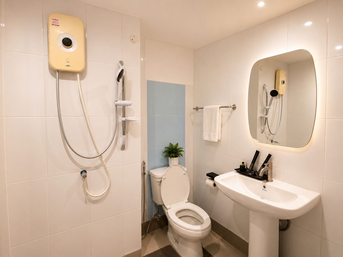 A modern bathroom with a toilet, sink, and shower unit.