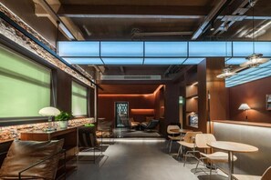 Un intérieur moderne avec un long couloir, des espaces de détente et un comptoir d’accueil.