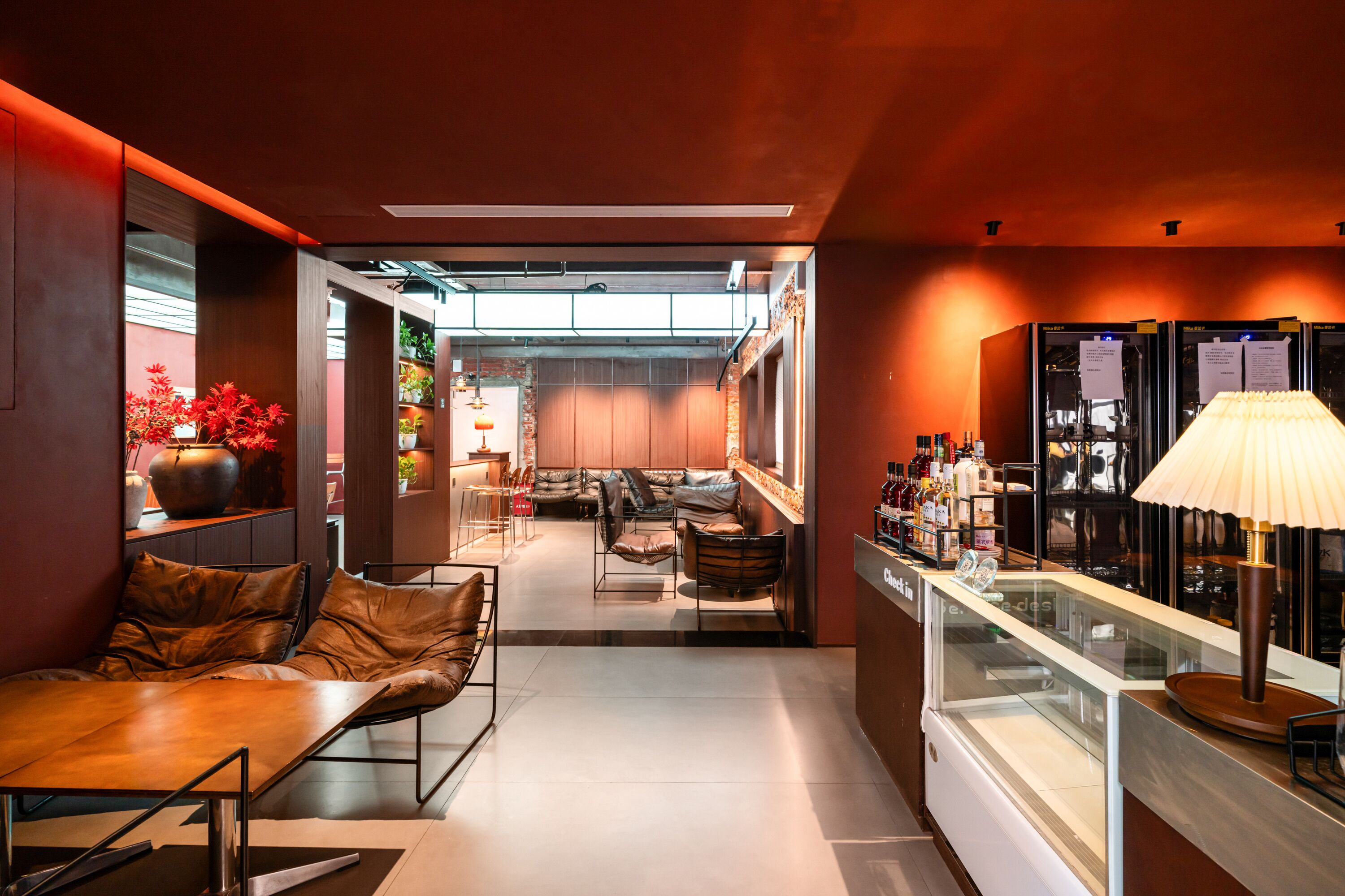A modern interior with a seating area, a bar, and a view into the dining space.
