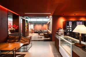 A modern interior with a seating area, a bar, and a view into the dining space. - Ru Wei Exquisite Hotel (Shanghai)