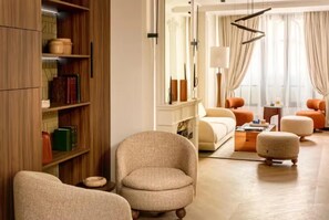 A living room with a sofa, armchairs, a coffee table, and a bookshelf. - PREMIUM 3-BEDROOM APARTMENT IN A PRESTIGIOUS PARIS NEIGHBORHOOD (Paris)