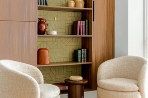 A room with a bookshelf, two armchairs, a small side table, and a patterned wall. - PREMIUM 3-BEDROOM APARTMENT IN A PRESTIGIOUS PARIS NEIGHBORHOOD (Paris)