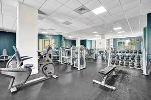 A gym with various exercise equipment, including treadmills, weight machines, and dumbbells. - Haven Beach Gem Condo in Hollywood (Hollywood)