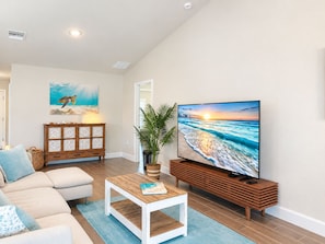 A living room with a sofa, coffee table, TV, and artwork. - 3BR Pool & Hot Tub Villa in Rotonda West (Rotonda West)