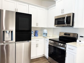 A modern kitchen with stainless steel appliances, white cabinetry, and a built-in oven. - 3BR Pool & Hot Tub Villa in Rotonda West (Rotonda West)
