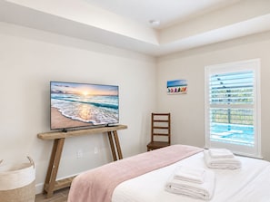 A bedroom with a bed, a television on a stand, a window with blinds, and a painting on the wall. - 3BR Pool & Hot Tub Villa in Rotonda West (Rotonda West)