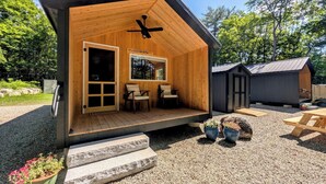 A wooden cabin with a porch, a ceiling fan, and a window with a view of trees. - Cabin at the lake, Free Kayaks, Hiking & Fishing (Franklin)
