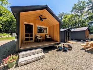 A wooden cabin with a porch, a ceiling fan, and a window with a view of trees. - Cabin at the lake, Free Kayaks, Hiking & Fishing (Franklin)