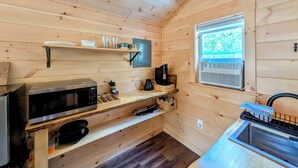 A compact kitchen with wooden walls, a microwave, a coffee maker, and a window with a view of greenery. - Cabin at the lake, Free Kayaks, Hiking & Fishing (Franklin)