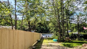 A dirt path leading to a body of water, surrounded by trees and a wooden fence. - Cabin at the lake, Free Kayaks, Hiking & Fishing (Franklin)