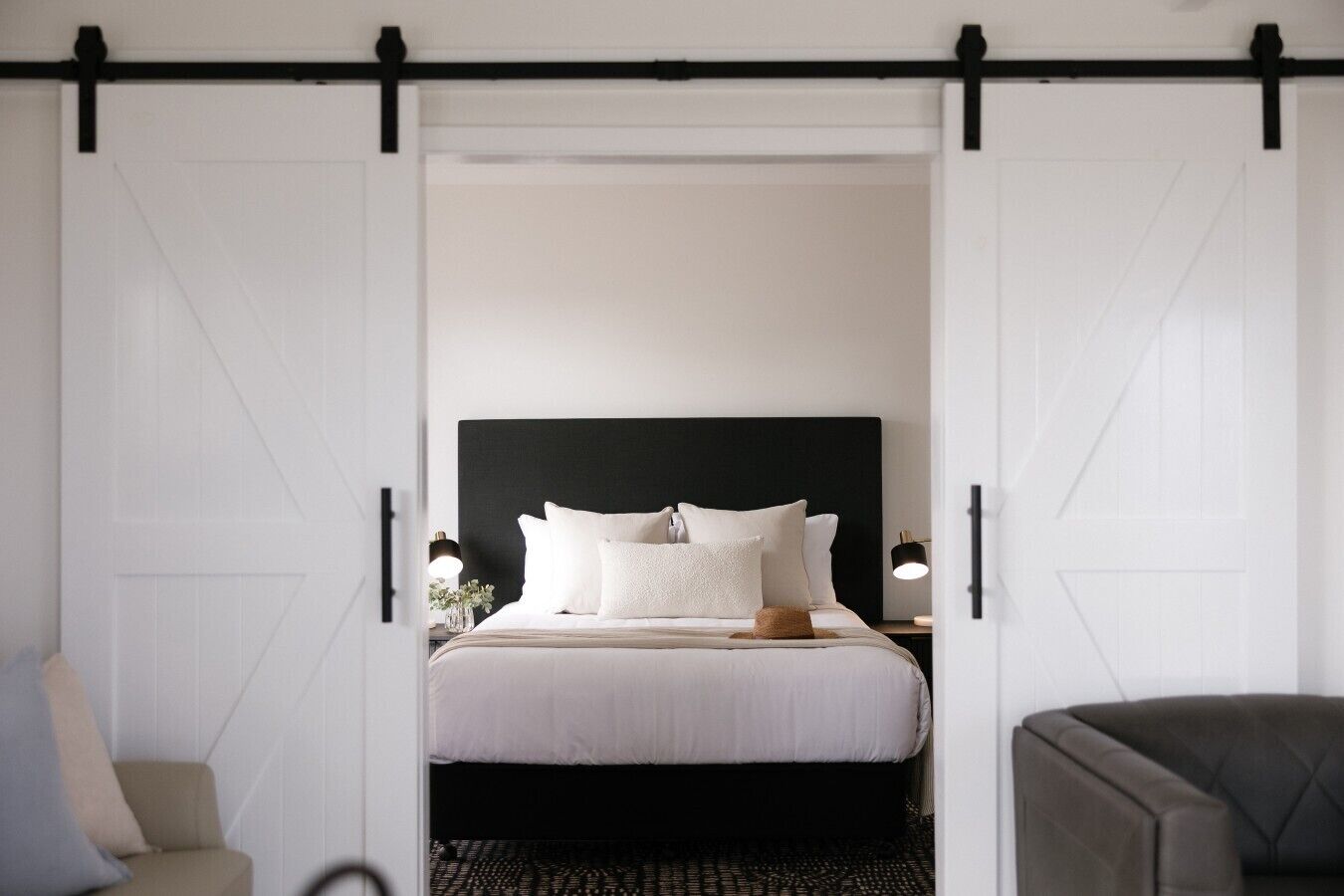 Un dormitorio con cama, mesitas de noche, una silla y un armario con puerta corredera.