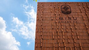 Une façade d’immeuble ornée d’un motif en briques et sur laquelle le nom « MIRU CHANGRA » est clairement affiché.