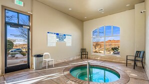 A pool area with a hot tub, a chair, and a window with a view of the desert. - Desert Haven, Private Spa, Community Amenities w/ Water Slide (Hurricane)