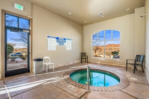 Ein Poolbereich mit Whirlpool, einem Liegestuhl und einem Fenster mit Blick auf die Wüste.