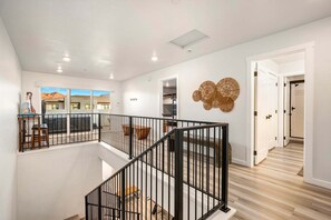 Un intérieur moderne avec un escalier, un coin repas et une vue sur l’extérieur.