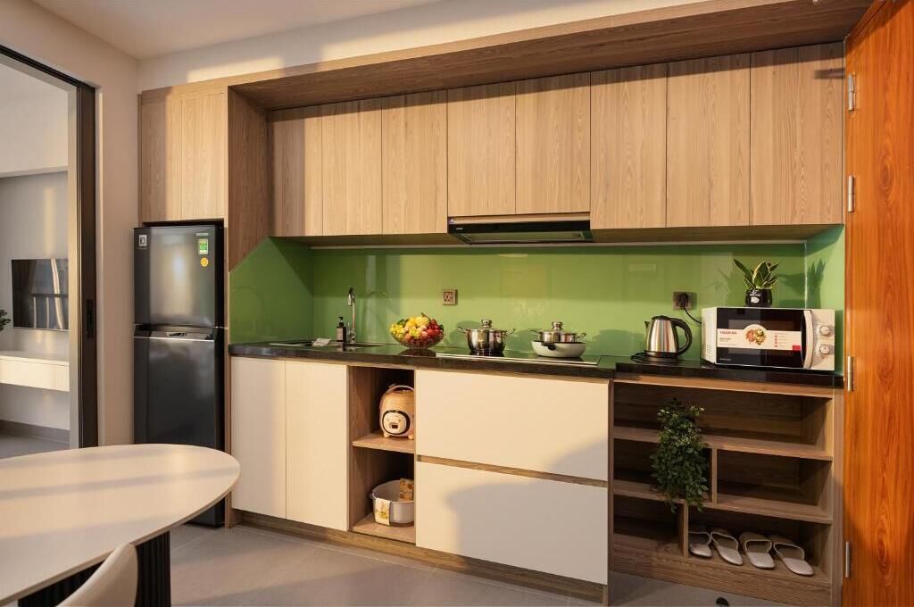 Et moderne køkken med træskabe, en grøn backsplash og en indbygget mikrobølgeovn.