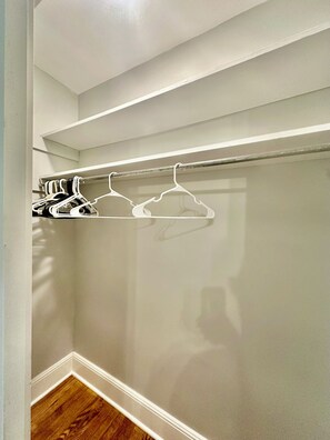 A closet with white hangers and a metal rod. - 4BR/3BTH Home in Eden, NC -Near Berry Hill Megasite & Martinsville Speedway (Eden)