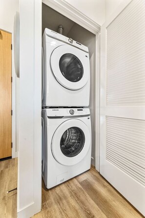 A laundry room with two stacked front-loading washing machines.