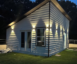 A white house with a gabled roof and a front door.