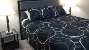 A bedroom with a bed, two bedside tables, a wall-mounted artwork, and a floor lamp. - 2 Condos Adjacent - for groups  4-Night DISCOUNT!! (Branson)