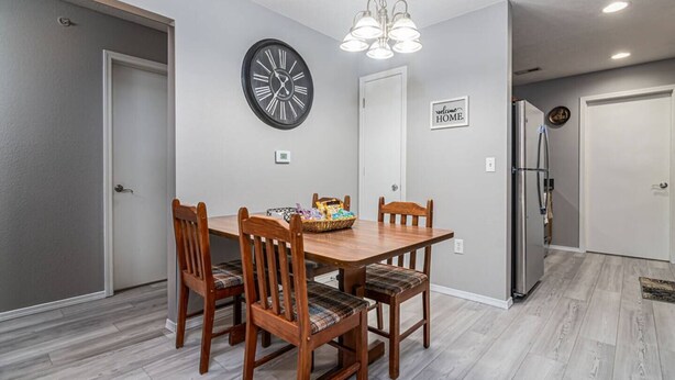 A dining area with a wooden table, four chairs, a clock, and a refrigerator. - 2 Condos Adjacent - for groups  4-Night DISCOUNT!! (Branson)