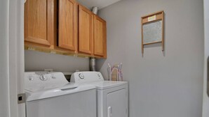 A laundry room with two stacked washers and dryers, wooden cabinets above, and a window with blinds. - 2 Condos Adjacent - for groups  4-Night DISCOUNT!! (Branson)
