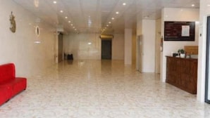 A spacious lobby with a reception desk, a red sofa, and a patterned floor. - Hung Phat Hotel Nghe An  (Hung Nguyen)
