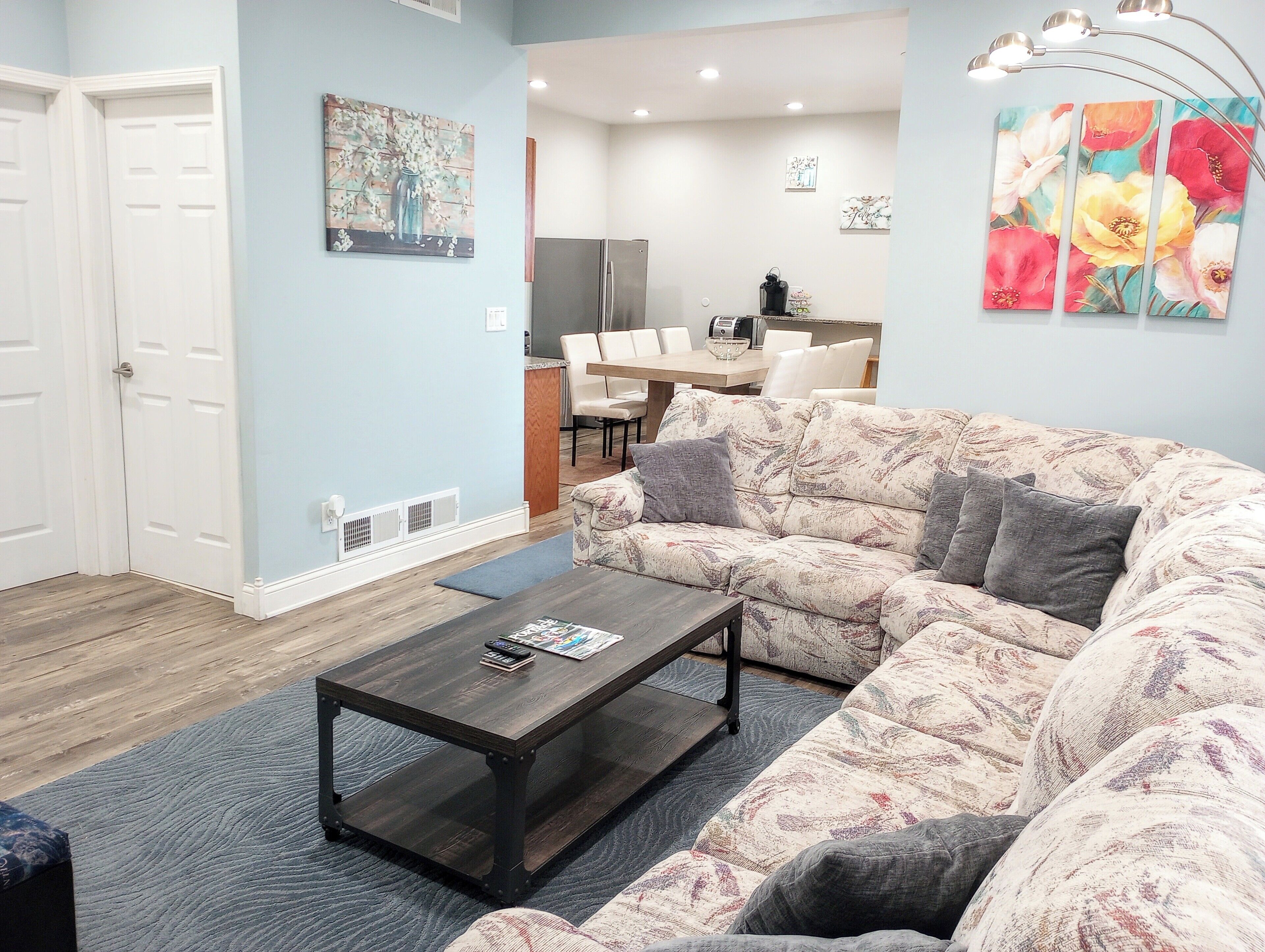 A living room with a sofa, coffee table, and artwork on the walls.