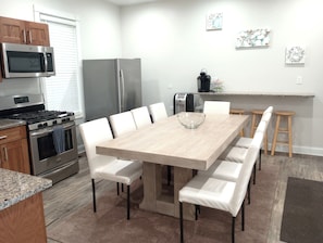 A modern kitchen with a dining table, white chairs, a microwave, a stove, and a refrigerator. - 6 Bedroom/6 Bathroom Dog Friendly Wisconsin Dells 13 min, Cascade Ski Hill 6min (Portage)