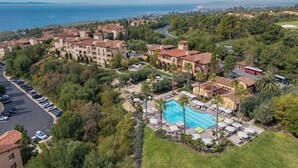 Ein Resort mit Schwimmbad, mehreren Gebäuden und Meerblick.