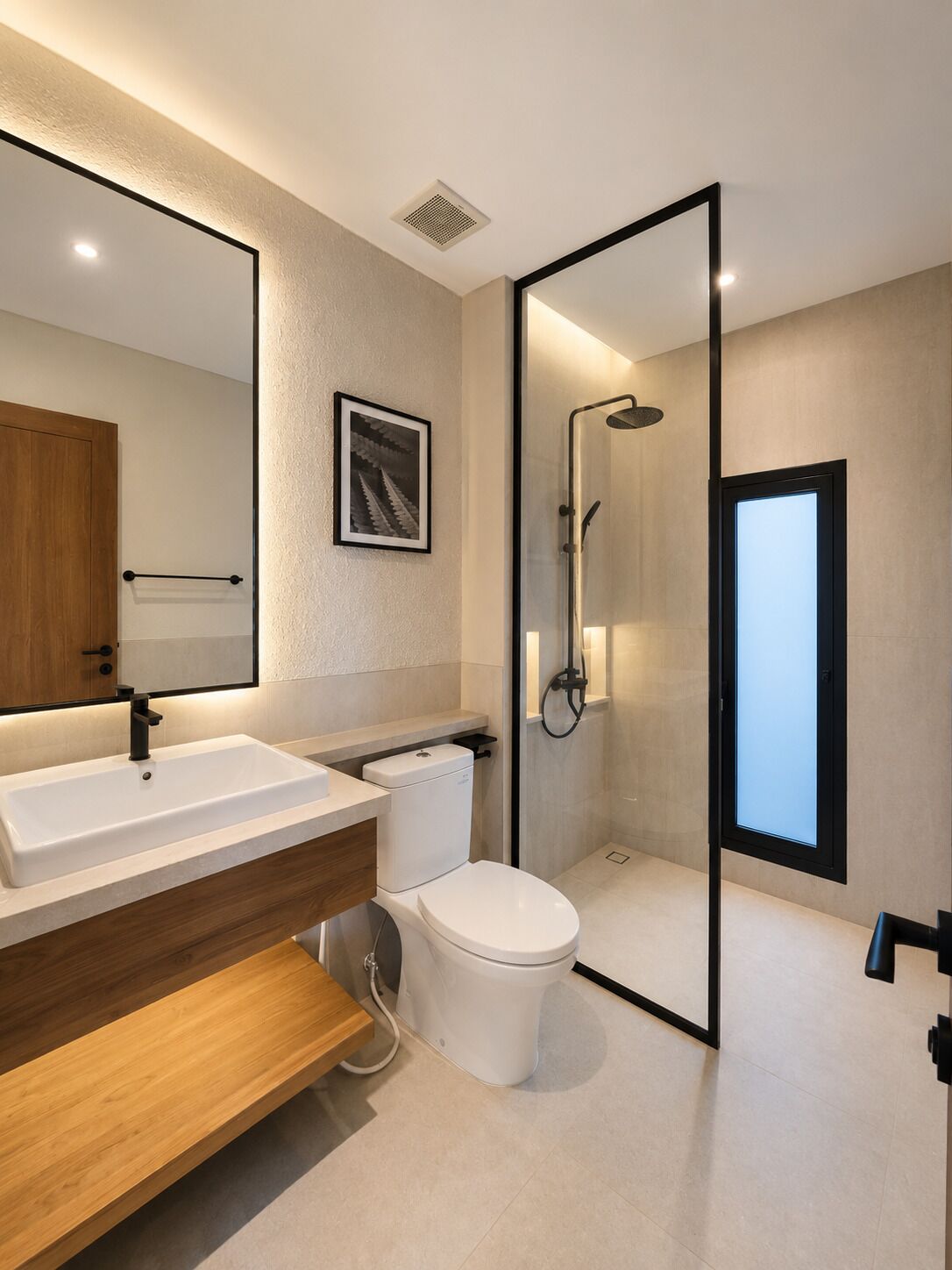 A modern bathroom with a large mirror, a sink, a toilet, and a shower.