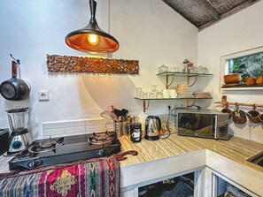 A kitchen with a gas stove, a blender, a kettle, and a microwave on the counter. - GANESH Ubud Entire Villa - Private Pool (Gianyar)