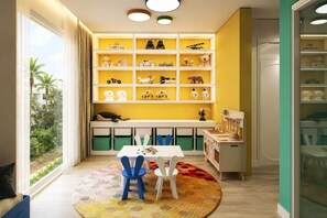 A child's playroom with a large window, shelves with toys, a table with chairs, and a colorful rug. - BRAND NEW The Palm Reserve Luxury Beach Villa Thailand (4 bedrooms/ 5 bathrooms) (Pak Nam Pran)