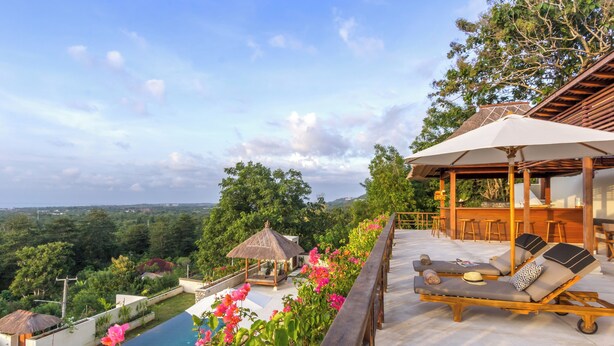 A rooftop terrace with a pool, lounge chairs, a bar area, and a thatched-roof structure. - Villa Bayu Uluwatu (denpasar)