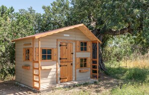 Een klein houten vakantiehuisje met een schuin dak, een voordeur en een raam.